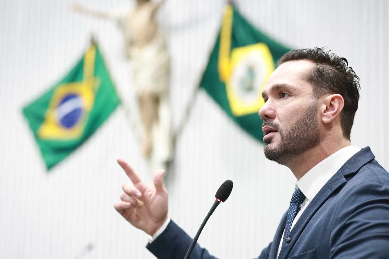 Guilherme Bismarck em discurso no plenário, com as bandeiras do Brasil e do Ceará